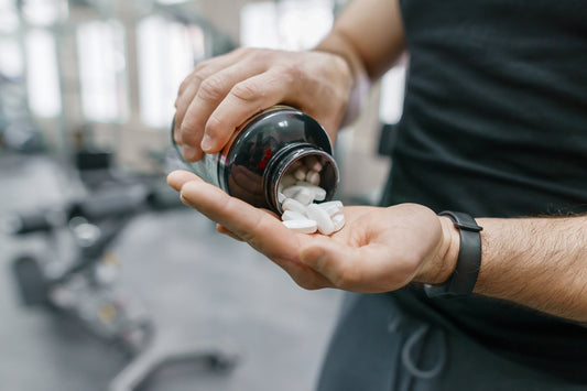 A man pours out some vitamins into his hand. What vitamins cause gas and bloating? Check out our comprehensive guide on the surprising truth behind your supplements.