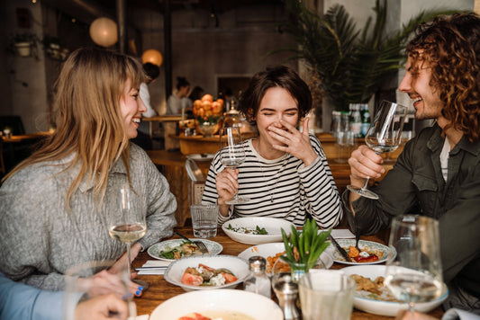 A group of friends at a restaurant. You can't always control when gas happens, but you can control how noticeable it is. See what actually helps manage gas odor in public.