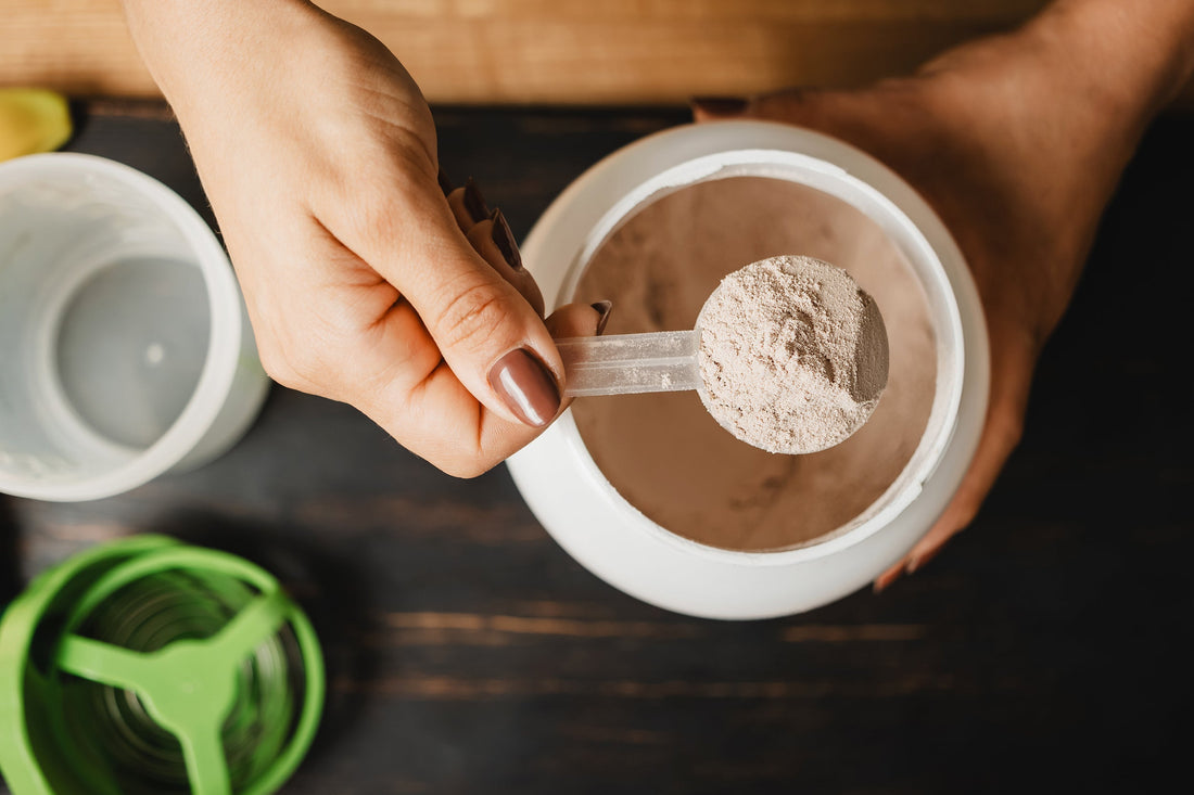 A woman scoops out protein powder. Farting more on a high protein diet? Protein farts and real. Here's what to do about them.