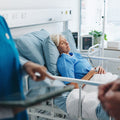 A woman laying in a hospital bed. Post-surgical gas is one of the most common — and least-warned-about — parts of recovery. Learn what actually helps, from walking to heat to odor-filtering underwear.