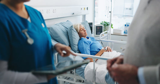 A woman laying in a hospital bed. Post-surgical gas is one of the most common — and least-warned-about — parts of recovery. Learn what actually helps, from walking to heat to odor-filtering underwear.