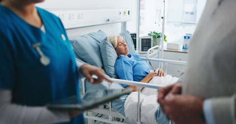 A woman laying in a hospital bed. Post-surgical gas is one of the most common — and least-warned-about — parts of recovery. Learn what actually helps, from walking to heat to odor-filtering underwear.