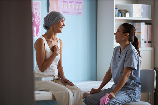 A woman undergoing cancer treatment talks with a medical worker. Learn what helps with gas during cancer treatment in our complete guide.