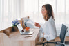 A woman clutches her stomach at work. If you've ever wondered, what is bubble gut, explore our complete guide on what it is and how to get relief.